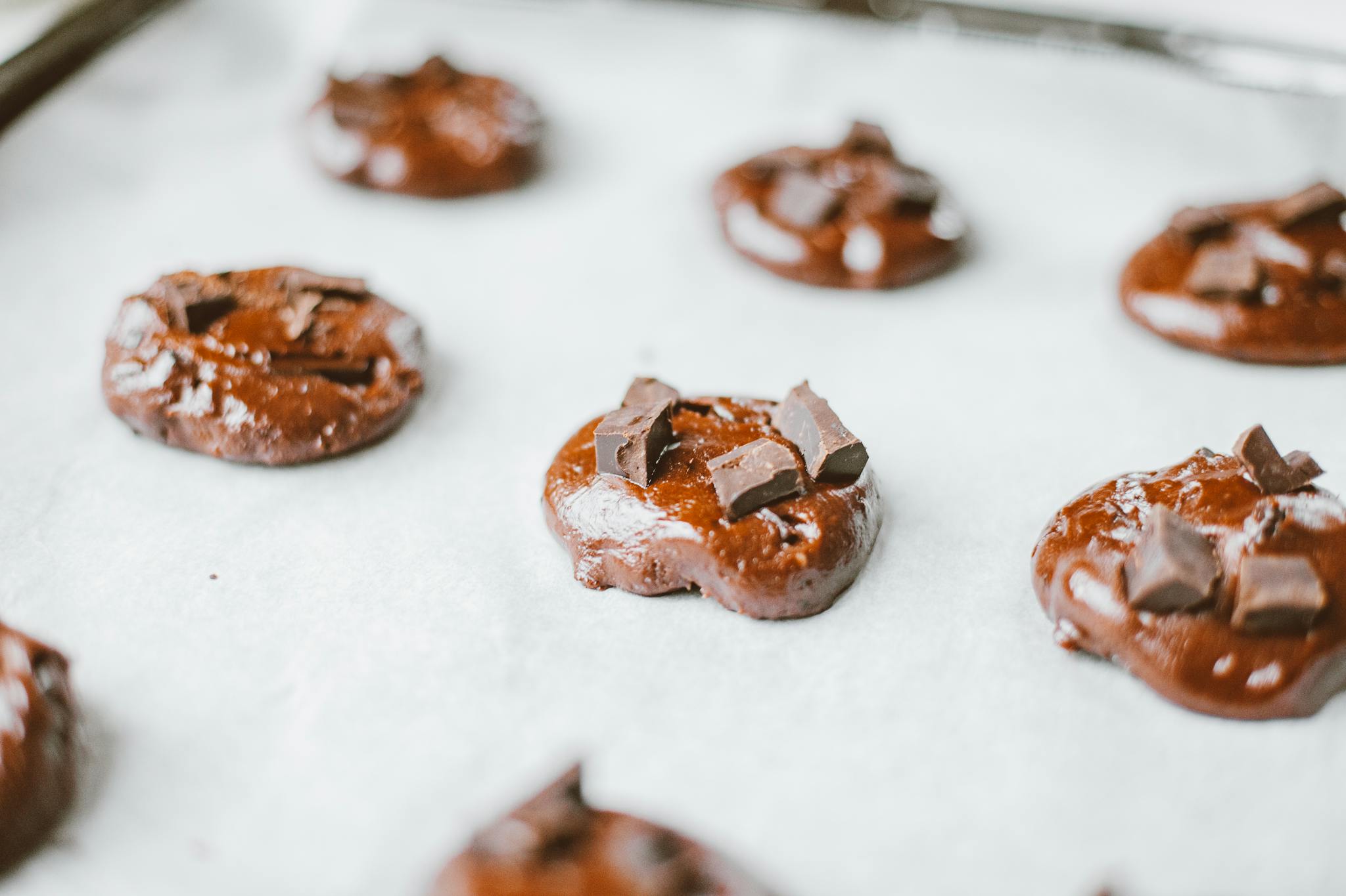 Close-up of raw chocolate cookies on a baking tray, ready to bake.