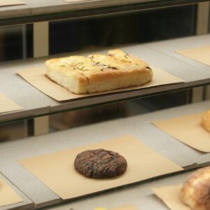 Freshly baked goods neatly arranged in a bakery display case showcasing variety.